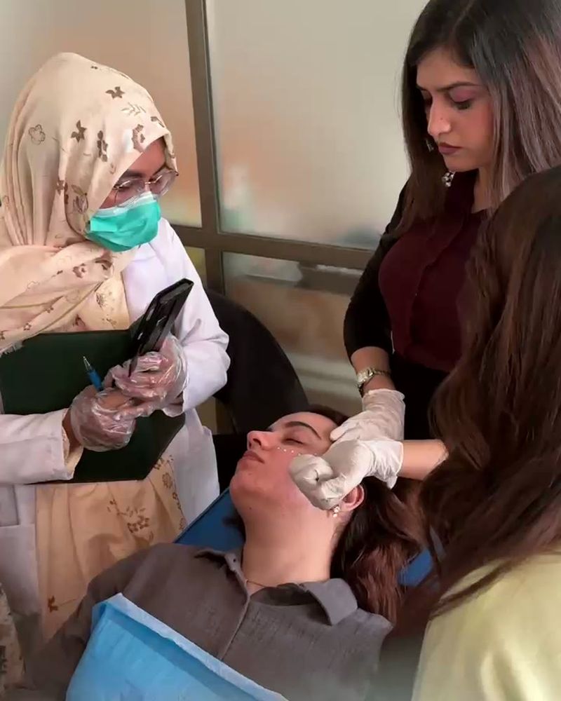 Participants gather round the treatment chair to watch